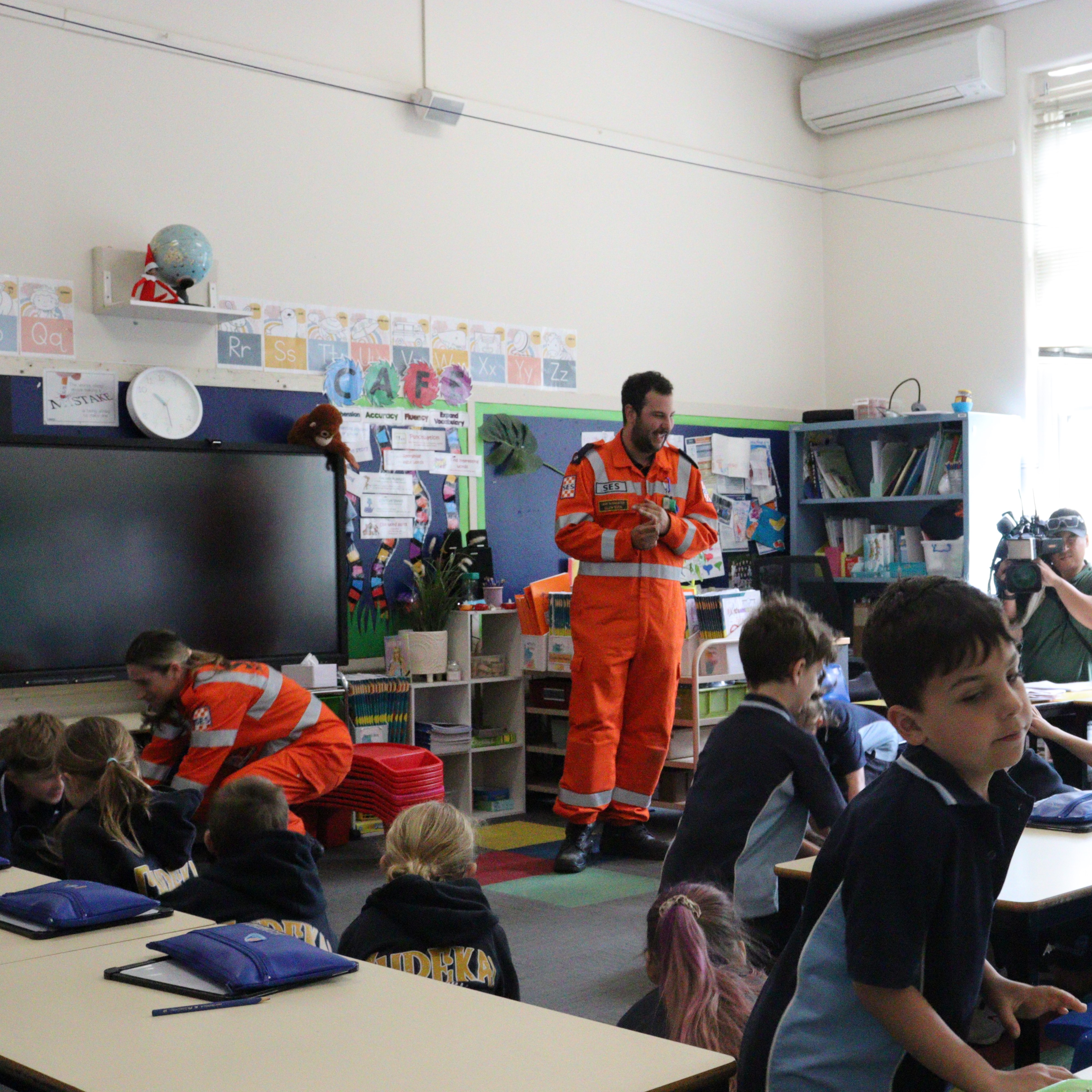 VICSES Glen Eira Unit volunteer Jake Schachter watches on as Jasmine Lewkowicz joins Gardenvale Primary School students in ducking for cover to simulate an earthquake response.